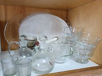 Shelf showing platter, cruets, dessert cups, gravy boat and other items