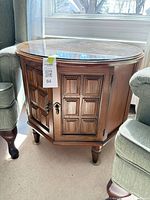 Full view of octagonal side table showing glass top and cabinet doors