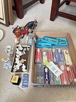 Group shot showing spoons in box, tray of animal figurines, larger figurines and horse