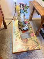 Wooden stool with figurine on top