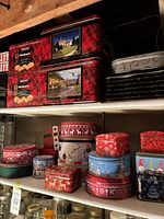 Shelf containing multiple decorative cookie tins in holiday designs