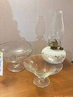 Oil lamp and two pedestal bowls grouped on tabletop