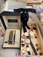 Overall view showing Seiko boxed watch, additional watches, lapel pins and bow tie
