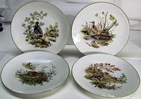 All four plates showing different wildlife motifs and green rims