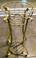 Full view of cream/yellow metal plant stand with three levels