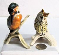 Front view of both bird figurines with coin for scale