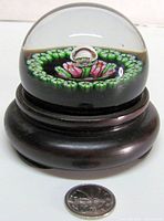 Paperweight on wood stand with quarter for scale