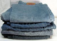 Stack of five blue denim jeans folded