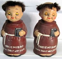 Front view of both monk coin banks showing inscription and design