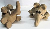 Front view of both beige ceramic elephant figurines