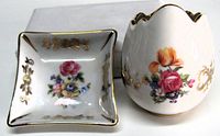 Front view of egg vase and trinket dish showing floral motifs and gilt trim
