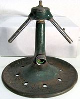 Full view of sprinkler showing base, riser, and twin arms