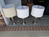 Three table lamps lined up showing overall design and shades