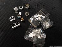 Overview of all loose and bagged rings on black surface