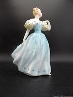 Front three-quarter view showing full figurine, dress details, pose