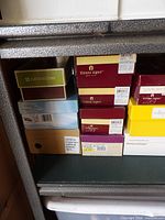 Stack of shoe boxes showing brands Naturalizer, Etienne Aigner and others