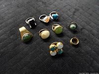 All nine rings laid out on fabric