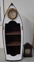 Full view of boat-shaped shelf with porthole clock and separate mantel clock