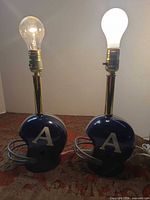 Two novelty helmet lamps side by side with bulbs illuminated