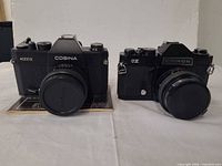 Front view of both cameras, Cosina 4000S and Chinon CX, with lens caps fitted