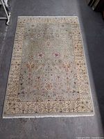 Full view of hand-knotted wool rug showing size, pattern, fringe