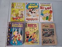 Six comics: Sad Sack, Atomic Mouse, Dennis the Menace Bonus Special, Richie Rich Millions (forest door), Popeye the Sailor, Western “The Kid” (partial cover)