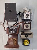 Group shot of all four cameras, flash reflector, leather case, Sunpak box