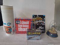 Group shot of entire lot showing cups stack, trivia game, keychain, card box and cat music box