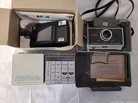 Overall lot with Polaroid camera in case, Minolta camera in box, portrait kit, chart card