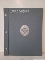 Front cover of grey cloth binder with emblem and bilingual title