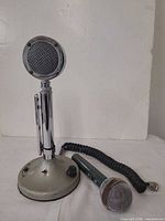 Desktop microphone, handheld microphone and coiled cable grouped on table