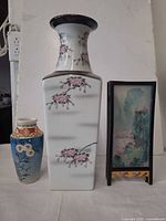 Group shot of tall square vase, small bud vase and folded screen