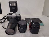 All items together: camera with flash and telephoto lens attached, second zoom lens, lens case, manual