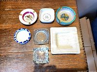 Seven ashtrays displayed top and bottom rows