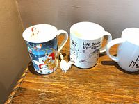Two tall mugs: holiday Santa motif and retirement cartoon