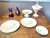 All seven porcelain and ceramic items displayed on table
