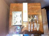 Overhead view showing boxed pair of Planet Hollywood glasses, four Mikasa utensils and separate glass