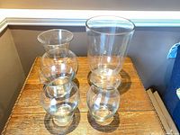 Four clear glass vases grouped on table