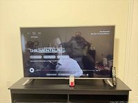 Front view of 65" LG smart TV powered on displaying streaming menu