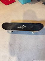 Top view of skateboard deck with grip tape logo