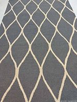 Full view of rug showing blue/grey field with beige lattice pattern