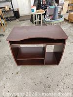 Front view of dark brown laminate computer desk showing top surface and open compartments