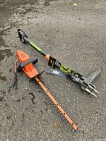 Edger motor housing, blade bar and weed puller on asphalt