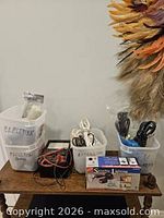 Three bins with extension cords, power cables, multimeter, earphone box and cable ties