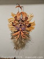 Full view of feather mask hanging against wall