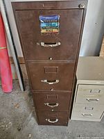 Front view of brown four-drawer metal file cabinet