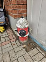 Full view of cement fire hydrant ornament beside wall