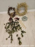 Assorted wreaths, garland, and wooden dowels laid out