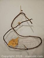 Full view of loon-shaped dream catcher showing branch frame and webbing