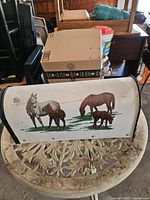 front side of white metal mailbox showing horse and foal artwork